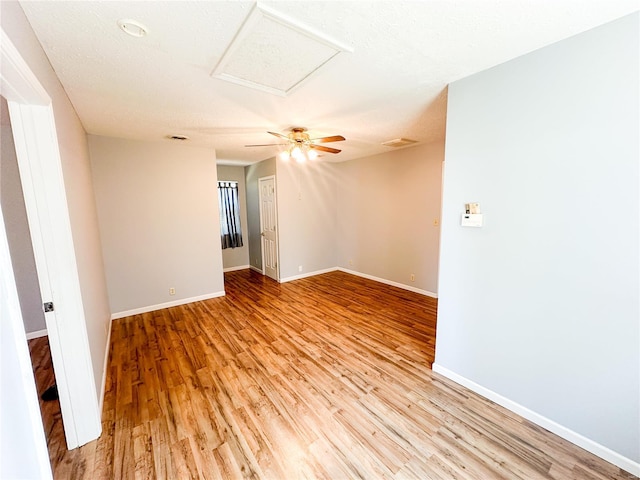 empty room with light wood-type flooring, a textured ceiling, and ceiling fan