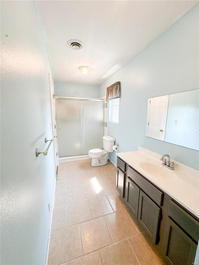 bathroom with a shower with door, a textured ceiling, tile patterned floors, toilet, and vanity