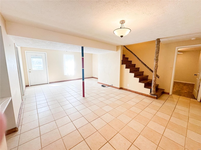 basement featuring a textured ceiling and light tile patterned flooring