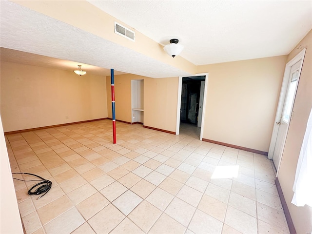 interior space featuring a textured ceiling, a wealth of natural light, and light tile patterned flooring