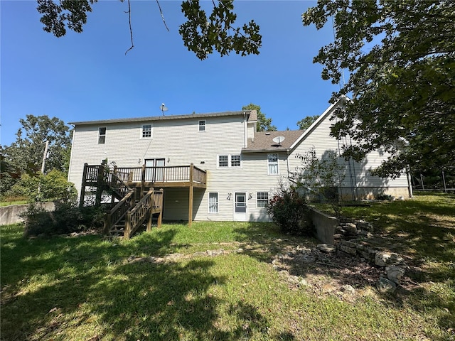 back of property with a yard and a wooden deck