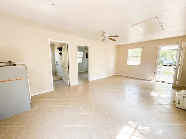 empty room with ceiling fan and light tile patterned flooring