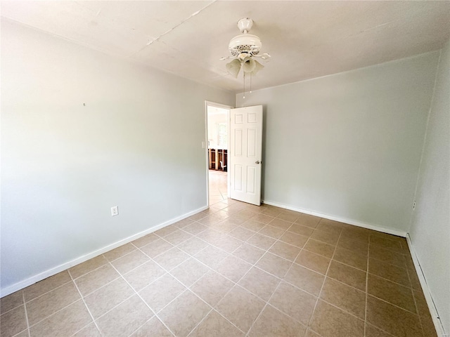 tiled spare room featuring ceiling fan