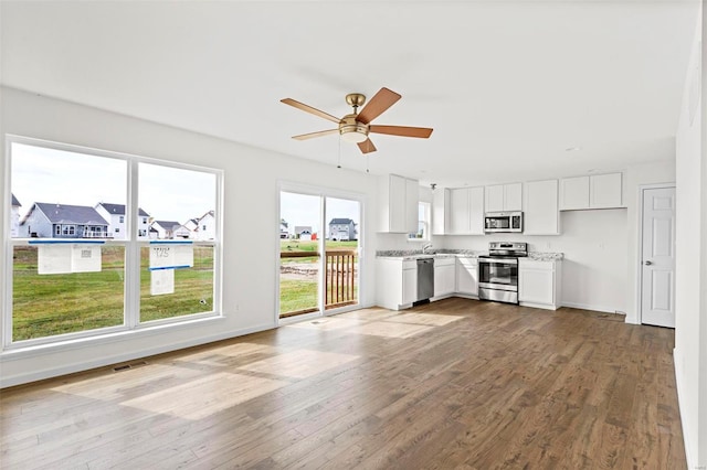 unfurnished living room featuring ceiling fan and wood-type flooring