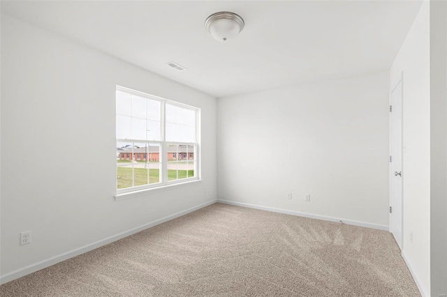 spare room with visible vents, carpet, and baseboards