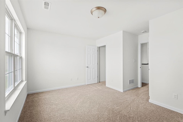 unfurnished room featuring visible vents, baseboards, and carpet flooring