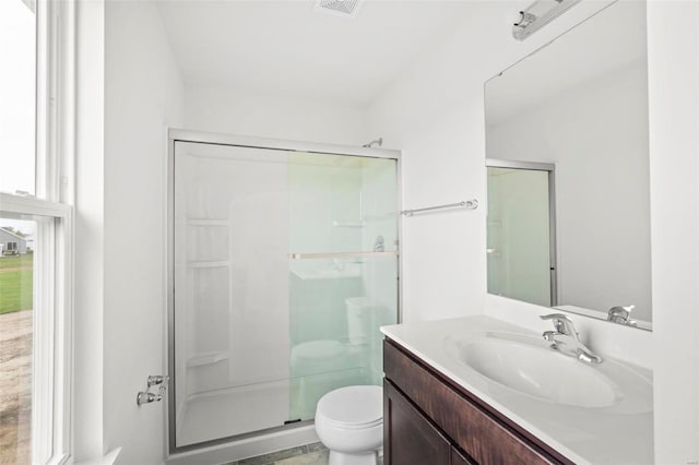 bathroom with vanity, a shower stall, and toilet