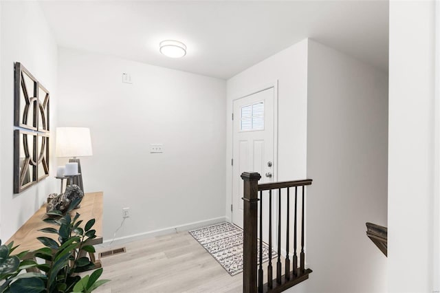 entryway with visible vents, baseboards, and wood finished floors