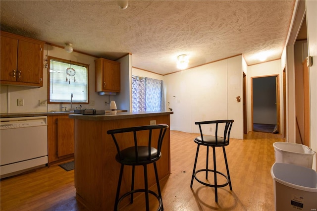 kitchen with white dishwasher, a kitchen island, light hardwood / wood-style floors, and a healthy amount of sunlight