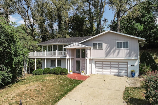 view of front facade with a balcony, a front yard, and a garage