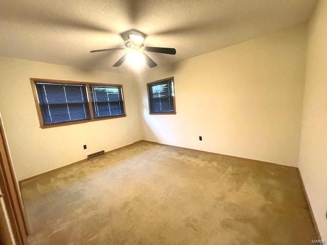 carpeted spare room with ceiling fan and a textured ceiling