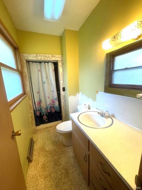 bathroom featuring a shower with shower curtain, vanity, toilet, and a wealth of natural light