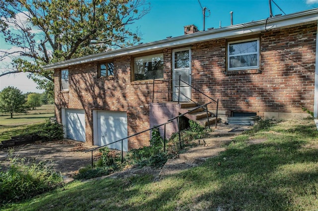 rear view of house with a yard and a garage