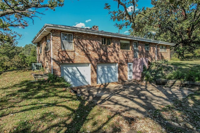 rear view of house featuring a garage and a yard