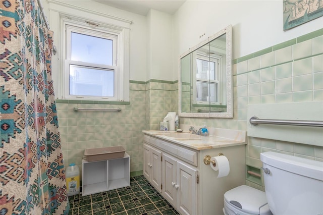 bathroom with a shower with shower curtain, vanity, tile walls, toilet, and tile patterned floors