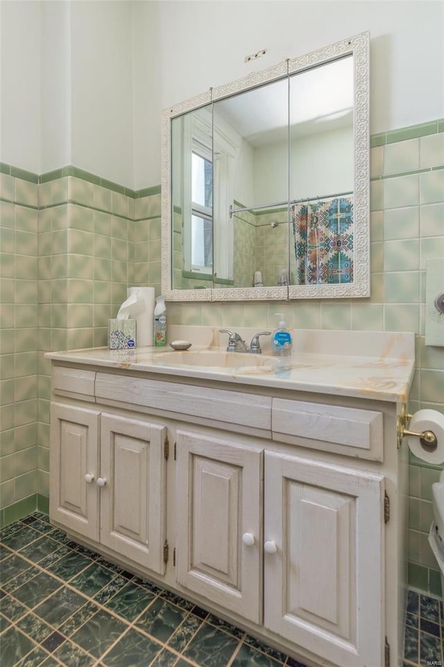 bathroom with vanity, toilet, tile walls, and walk in shower