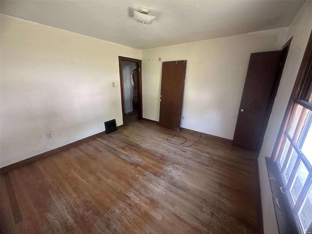 unfurnished bedroom with dark hardwood / wood-style floors