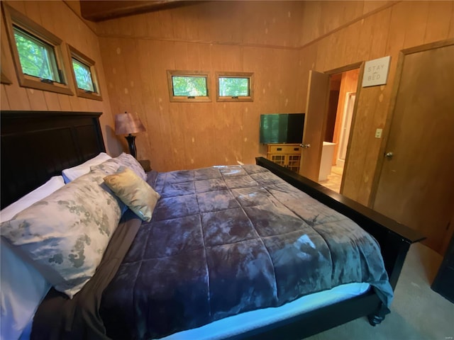 carpeted bedroom with wood walls