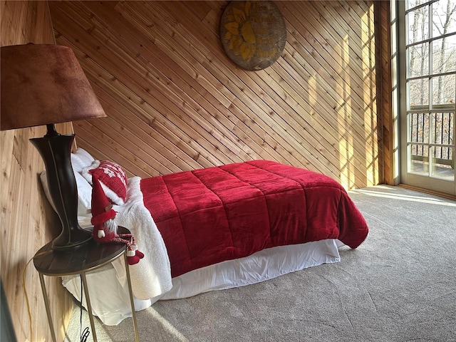 carpeted bedroom featuring wood walls