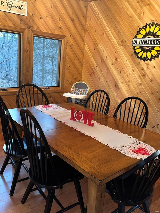 dining space with a healthy amount of sunlight and wooden walls