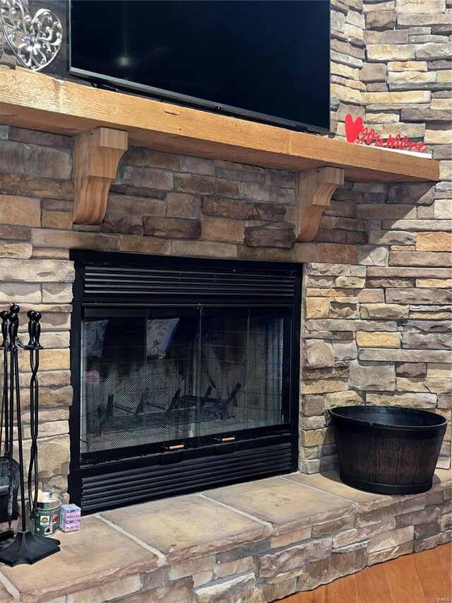 room details with hardwood / wood-style flooring and a stone fireplace