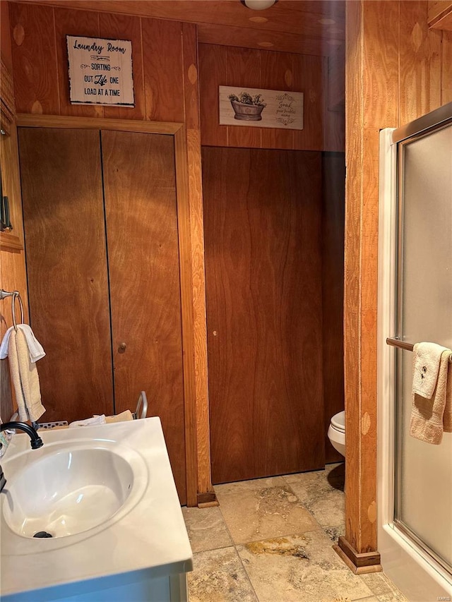 bathroom with a shower with door, toilet, and vanity