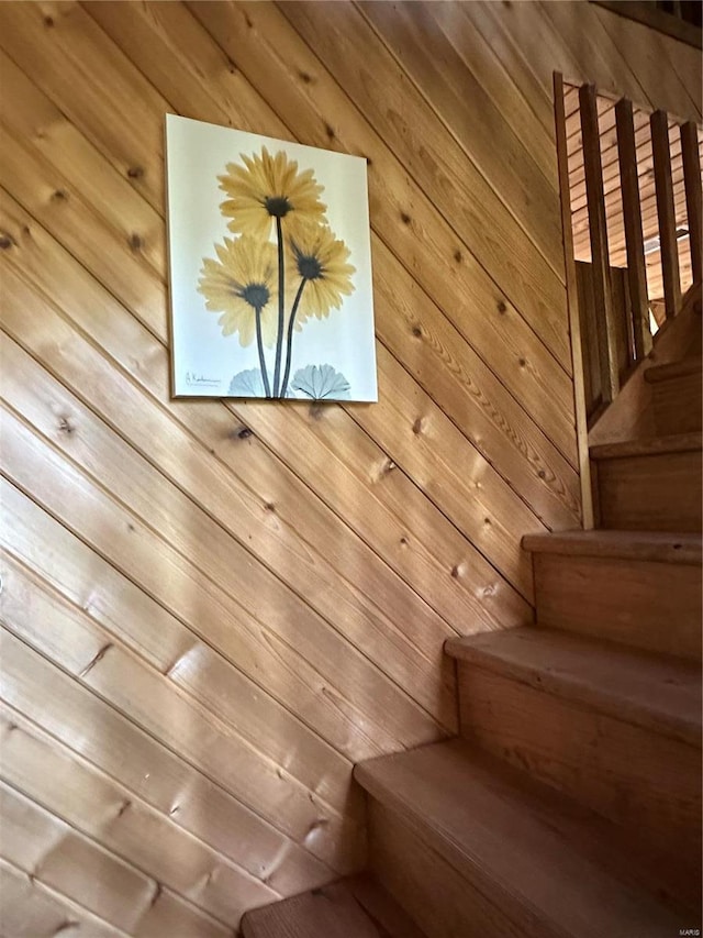 staircase featuring wood walls