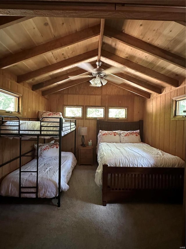 unfurnished bedroom with ceiling fan, carpet, wooden walls, and lofted ceiling with beams