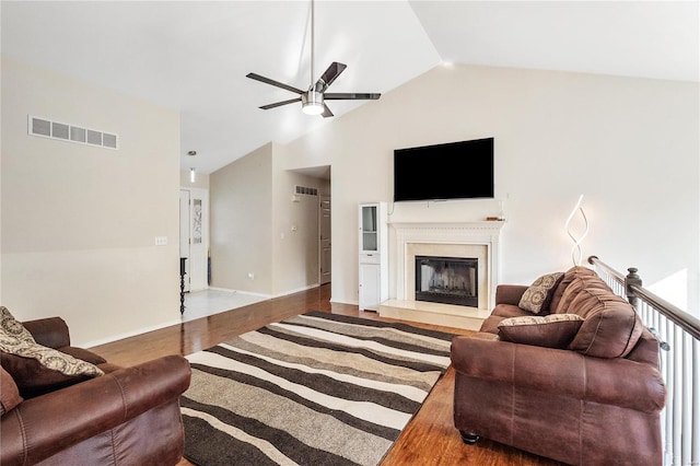 living room with lofted ceiling, ceiling fan, hardwood / wood-style flooring, and a high end fireplace