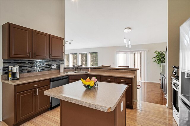 kitchen featuring dishwasher, backsplash, light hardwood / wood-style floors, kitchen peninsula, and sink