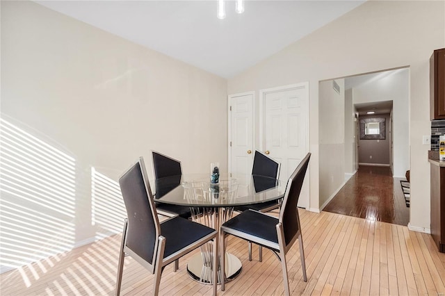 dining room featuring lofted ceiling and hardwood / wood-style flooring