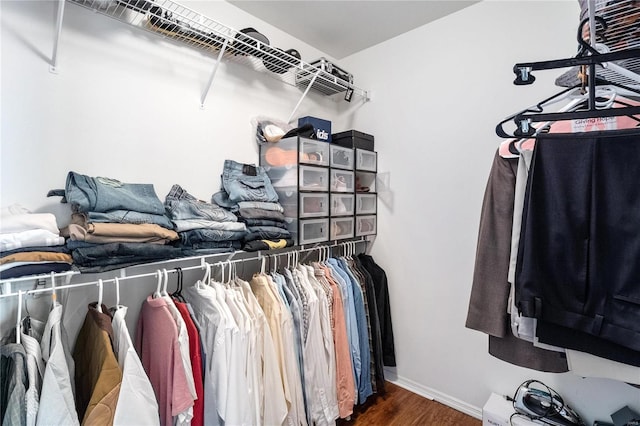 walk in closet with dark wood-type flooring