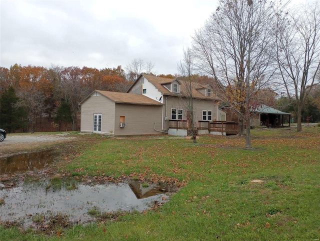 back of house featuring a lawn and a deck