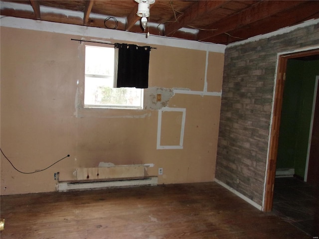 spare room with a baseboard radiator and hardwood / wood-style flooring