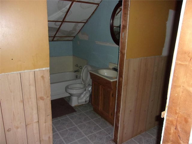 bathroom with vanity, wood walls, tile patterned flooring, a washtub, and toilet