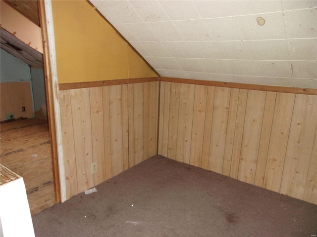 additional living space featuring lofted ceiling, carpet floors, and wooden walls