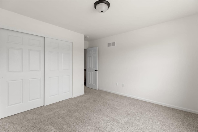 unfurnished bedroom featuring a closet and light carpet