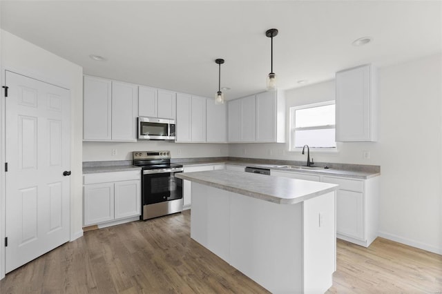 kitchen with white cabinetry, a kitchen island, stainless steel appliances, and sink