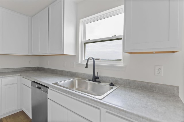 kitchen featuring dishwasher, sink, wood-type flooring, and white cabinetry