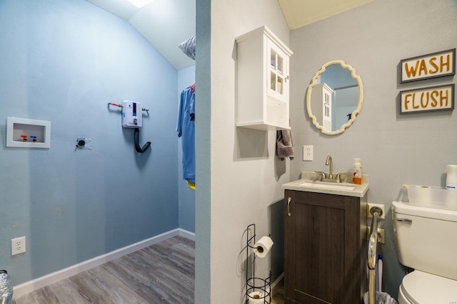 bathroom with vanity, toilet, hardwood / wood-style flooring, and lofted ceiling