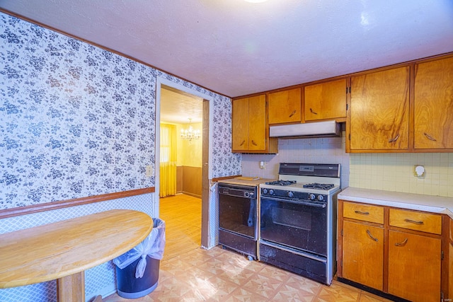 kitchen featuring a notable chandelier, a textured ceiling, white gas stove, black dishwasher, and light hardwood / wood-style floors