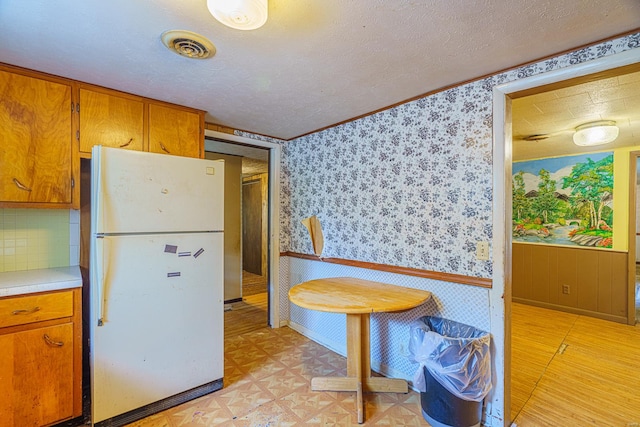 kitchen featuring white refrigerator and a textured ceiling