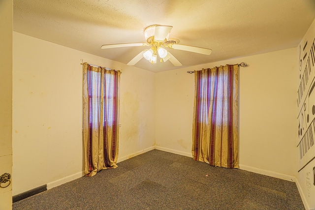 empty room featuring a textured ceiling, carpet, and ceiling fan