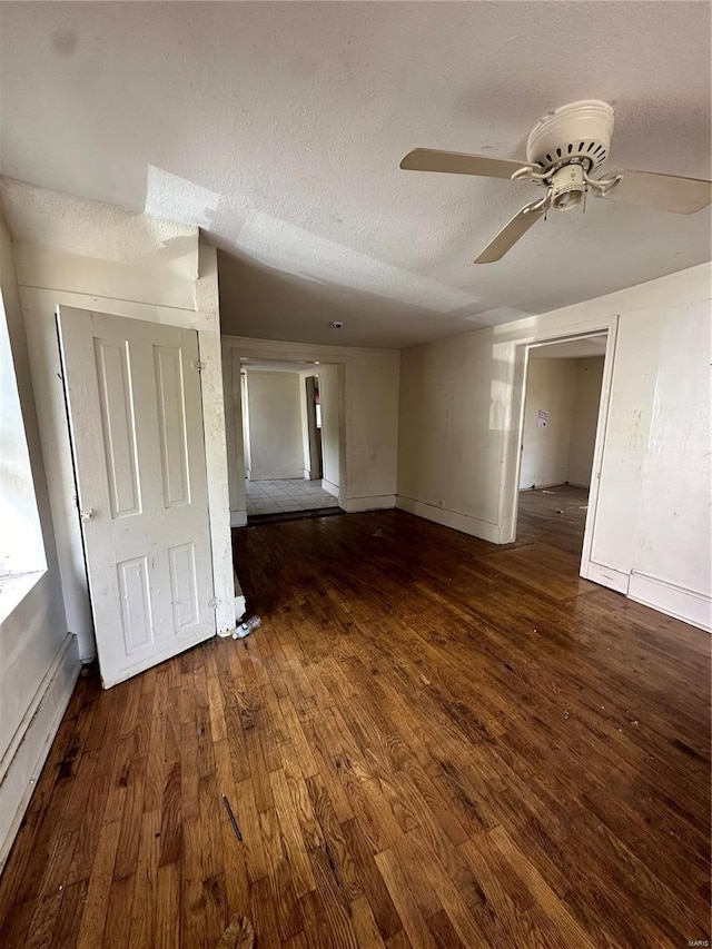 interior space with a textured ceiling, ceiling fan, and dark hardwood / wood-style floors