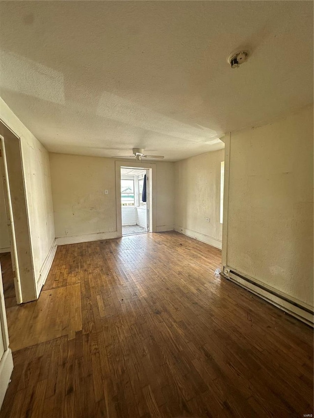 empty room with dark wood-type flooring and a textured ceiling