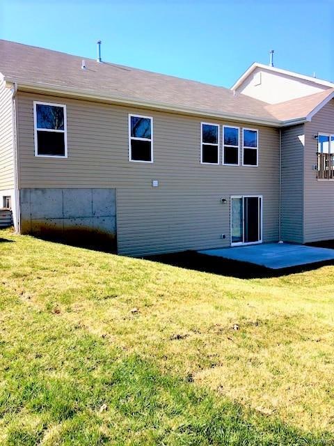 back of property featuring a patio area and a yard