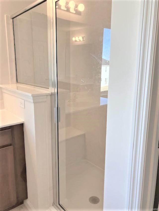 bathroom featuring vanity and a shower with door