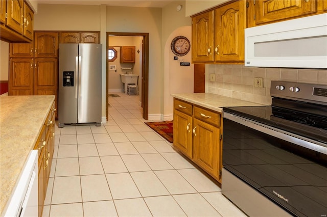 kitchen featuring appliances with stainless steel finishes, light tile patterned floors, and tasteful backsplash