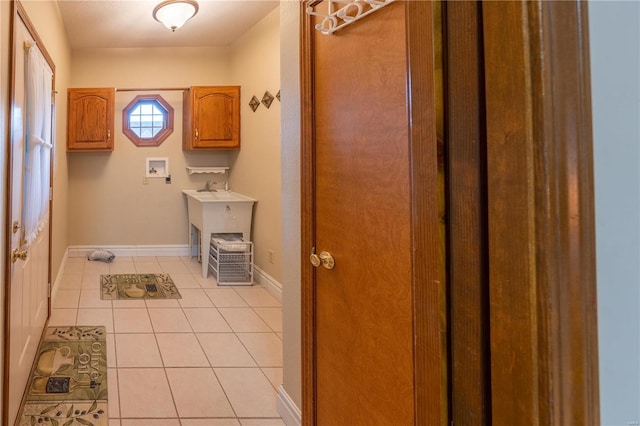 laundry room featuring hookup for a washing machine, cabinets, and light tile patterned floors