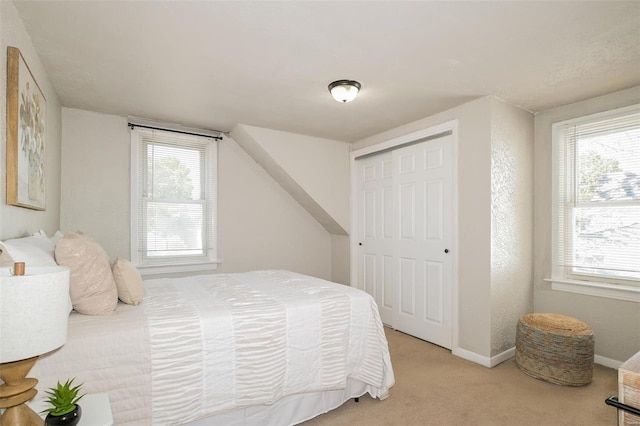 bedroom featuring light colored carpet, a closet, and multiple windows